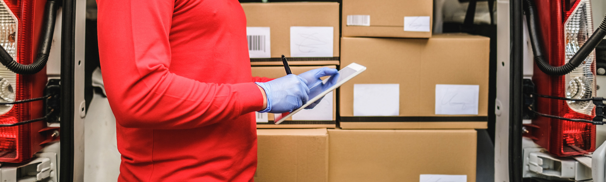 Young man outdoor of delivery transportation checking the package of costumer with digital tablet