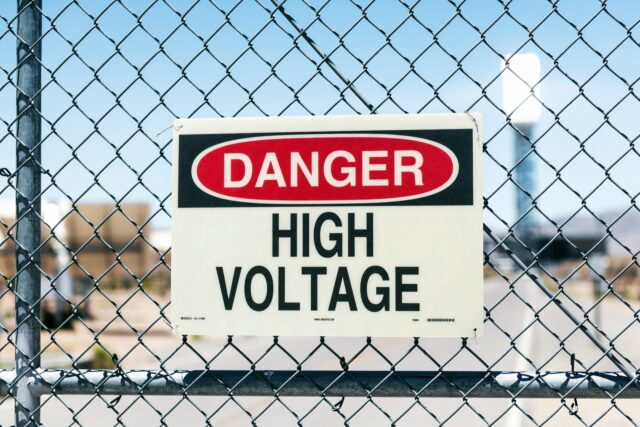 high voltage sign on chain link fence
